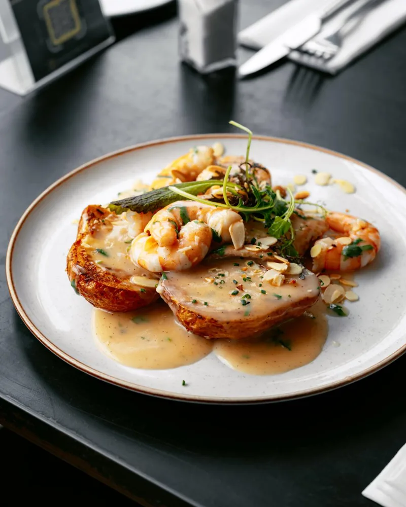 Buziano: filete de pescado en salsa de camarones con papas gratinadas